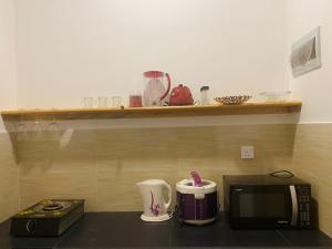 希卡杜瓦的住宿－The Cozy Nest，厨房柜台配有微波炉和咖啡壶