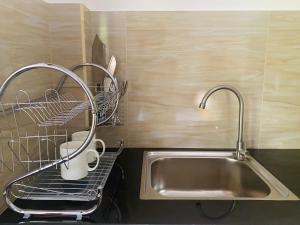 希卡杜瓦的住宿－The Cozy Nest，厨房水槽配有2个杯子和晾衣架
