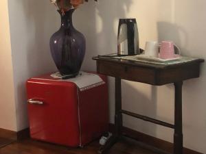 eine Vase auf einem roten Kühlschrank neben einem Tisch in der Unterkunft B & B Chic in Premariacco