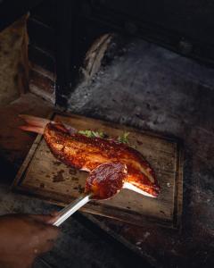 a person cutting a piece of meat on a cutting board at Villa Pescadores Tulum in Tulum