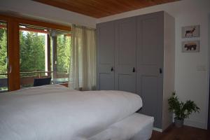 1 dormitorio con cama blanca y balcón en I dr Rehwiesa A25 en Arosa