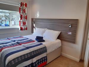 a bedroom with a bed with a blue hat on it at Smitten House 4 Bedroom RHYL in Rhyl