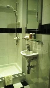a bathroom with a sink, mirror, and bath tub at Albany House in Penrith