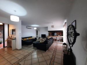 a living room with a black couch and a kitchen at Casa Gama in Ribeira Brava