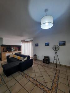 a living room with a couch and a clock on the wall at Casa Gama in Ribeira Brava