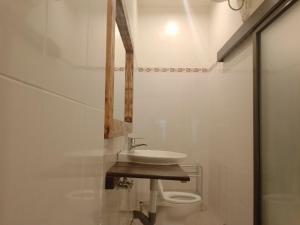 La salle de bains est pourvue d'un lavabo et de toilettes. dans l'établissement Yanti Guest House, à Canggu