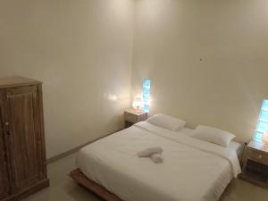 - une chambre avec un lit blanc et 2 tables de chevet dans l'établissement Yanti Guest House, à Canggu