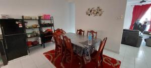 a dining room table and chairs in a living room at Nur Homestay Residensi Afamosa mslim guest only in Kampong Alor Gajah