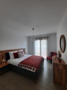 a bedroom with a bed and a table and a mirror at Casa Gama in Ribeira Brava