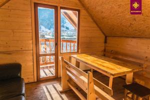 een houten tafel in een kamer met een groot raam bij Villa «Zlata» in Verkhovyna