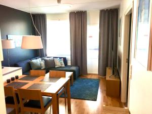 een woonkamer met een tafel en een blauwe bank bij Premium Chalet 4109 Blue in Vierumäki