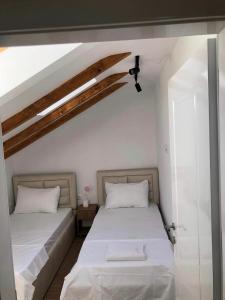 2 camas en una habitación con paredes blancas en Vila Emante, en Tushemisht