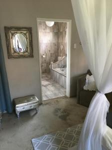 a bedroom with a bathroom with a tub and a mirror at Le Franz in Parys