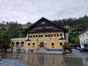 a large yellow building with a brown roof at Gasthof Post in Mittersill