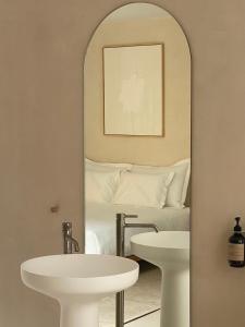 een spiegel in een kamer met een bed en een wastafel bij Olive studios in Zadar