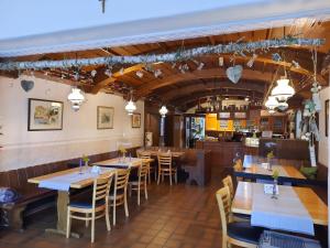 un restaurante con mesas y sillas de madera y una cocina en Gasthaus Post en Goldbach