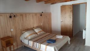 ランゴーニュにあるLangogne, appartement cœur de villeの木製の壁のベッドルーム1室(ベッド1台付)