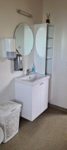 Baño blanco con lavabo y espejo en Guesthouse Stekkatún, en Skálafell