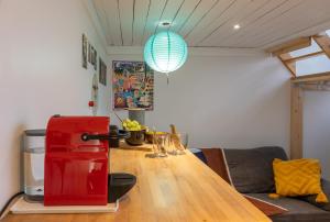 um quarto com uma mesa de madeira e um frigorífico vermelho em Le Studio Compostelle by Maison Brasseurs d'Etoiles em Liège