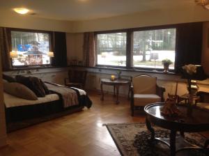 a living room with a bed and a table and windows at Apartment Nonna in Keuruu