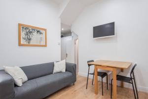 Comfortable flat in Hammersmith في لندن: غرفة معيشة مع أريكة وطاولة