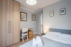 Comfortable flat in Hammersmith في لندن: غرفة نوم مع سرير ومكتب