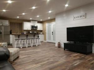 a living room with a large flat screen tv at Harbour Village Retreat in Garden City +31 photos