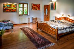 1 dormitorio con cama de madera y alfombra en Rezydencja Golland en Krzywe