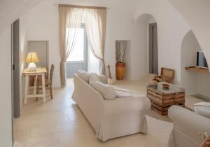 salon z białymi meblami i dużym oknem w obiekcie Trulli sul Mare Forcatella w mieście Savelletri di Fasano