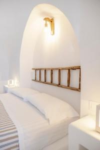 łóżko w pokoju z białą ścianą w obiekcie Trulli sul Mare Forcatella w mieście Savelletri di Fasano