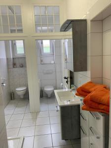 ein weißes Bad mit einem Waschbecken und einem WC in der Unterkunft Erboys Ferienwohnung in Goslar