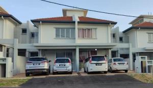 un groupe de voitures garées devant une maison dans l'établissement Nur Homestay Residensi Afamosa mslim guest only, à Kampong Alor Gajah