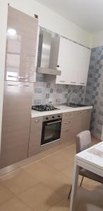 a kitchen with white cabinets and a stove top oven at casa anna in Vico Equense