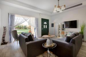 a living room with a couch and a tv at Heliophos Villa Aitheria in Kiotari