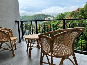 a balcony with two chairs and a table with a view at Hidden relaxation at Kings residence in Kandy