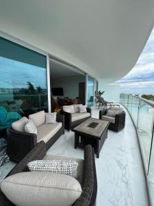 - un balcon avec des canapés et des tables dans un bâtiment dans l'établissement Maritima Playa Deluxe Ocean View Vallarta, à Nuevo Vallarta