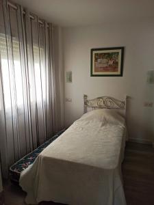 um quarto com uma cama com uma colcha branca em Palamos Carrer Del Mar em Palamós