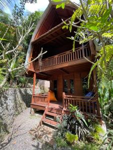 a house with a porch and two benches in front of it at Bulian Homestay in Kubutambahan