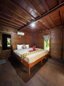a bedroom with a bed in a wooden room at Bulian Homestay in Kubutambahan