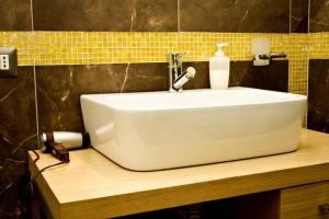 布加勒斯特的住宿－德古拉探險之旅公寓，浴室内木制柜台上的白色水槽