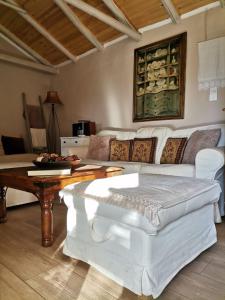a living room with a white couch and a table at Sofias cottage in Elliniko