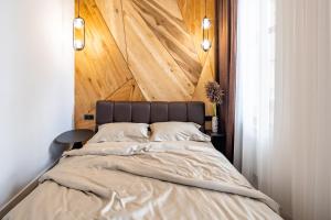 リヴィウにあるRomari Таманська 12のベッドルーム1室(大型ベッド1台、木製ヘッドボード付)