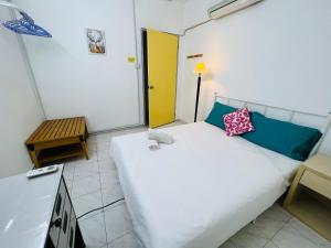 クアラルンプールにあるKL Rinas Best Homestay at Bukit Bintang City Centerのベッドルーム1室(白いベッド1台、黄色いドア付)