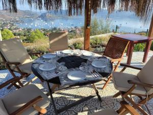 a table and chairs with a view of the ocean at Harmanyeri Tatilevi in Selimiye