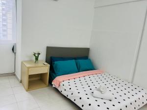 ein kleines Schlafzimmer mit einem Bett und einem Nachttisch in der Unterkunft KL Rinas Best Homestay at Bukit Bintang City Center in Kuala Lumpur