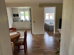 a kitchen and dining room with a table and a bed at Nice apartment, rural idyll just outside Karlstad in Karlstad