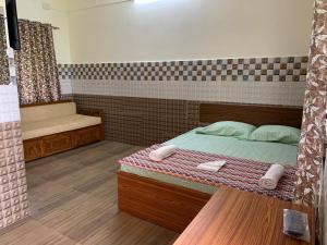 a bedroom with a bed with two towels on it at Sarovar's Nest in Avas