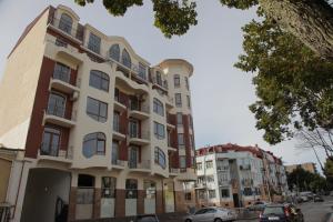 a tall building with cars parked in front of it at Apartment with Summer Terrace in Batumi