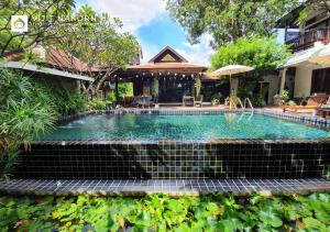 a swimming pool with a staircase leading to a house at Vijit Nakorn Hotel in Si Sa Ket