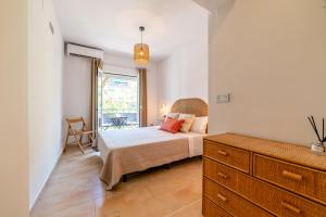 a bedroom with a bed and a dresser and a window at Apartamento Ronda Genil con parking gratuito in Granada
